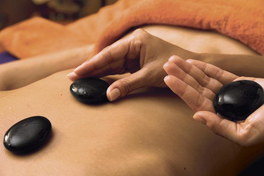 welldiana-hot-stone-massage Heiße Steine werden bei einer Hot Stone Massagen auf den Rücken gelegt