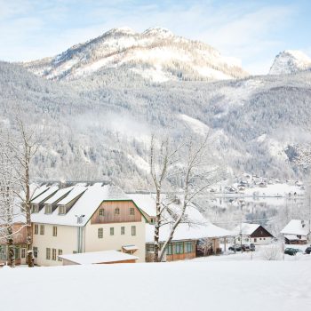 Aussenansicht vom JUFA Hotel Grundlsee im Winter. Der Ort für tollen Urlaub an schönen Seen für die ganze Familie.